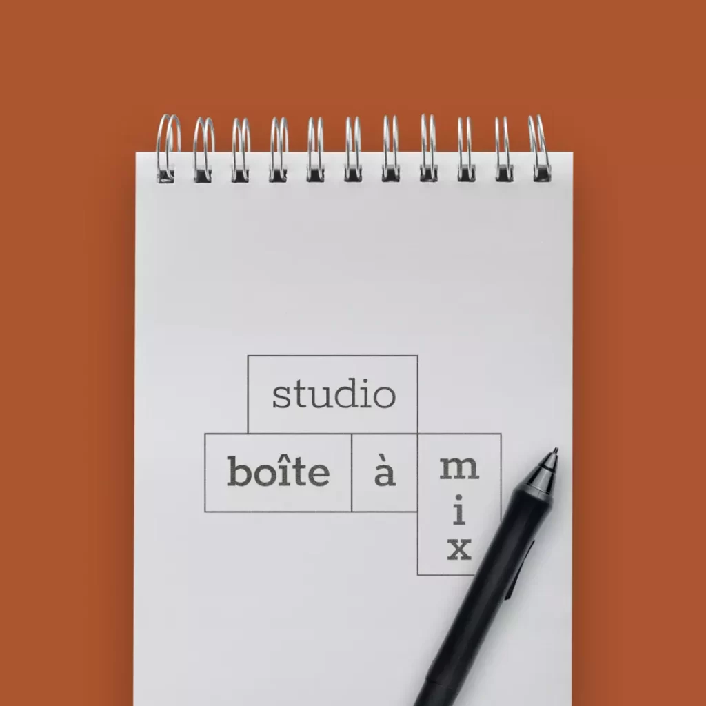 Mise en situation du logo principal de Boite À Mix sur un carnet de dessin. Logo dynamique.